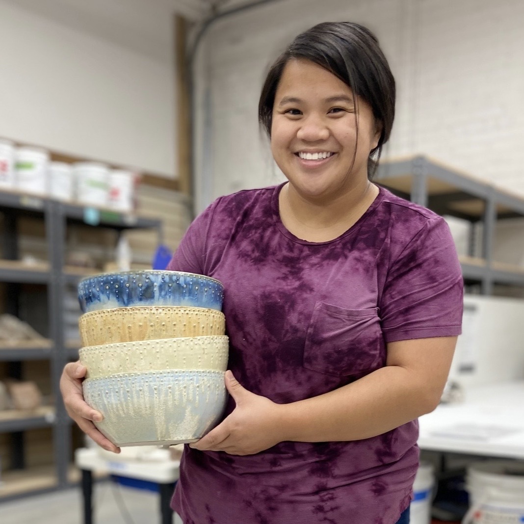 Katie Meili Messersmith holding stack of dotted serving bowls in ISM studio, dot pots Katie Meili Messersmith holding stack of dotted serving bowls in ISM studio, dot pots