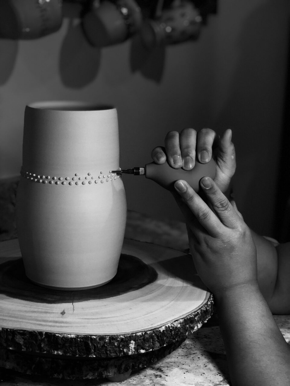 Katie Meili Messersmith close up of hands adding slip trailed dots to leather hard pot Katie Meili Messersmith close up of hands adding slip trailed dots to leather hard pot