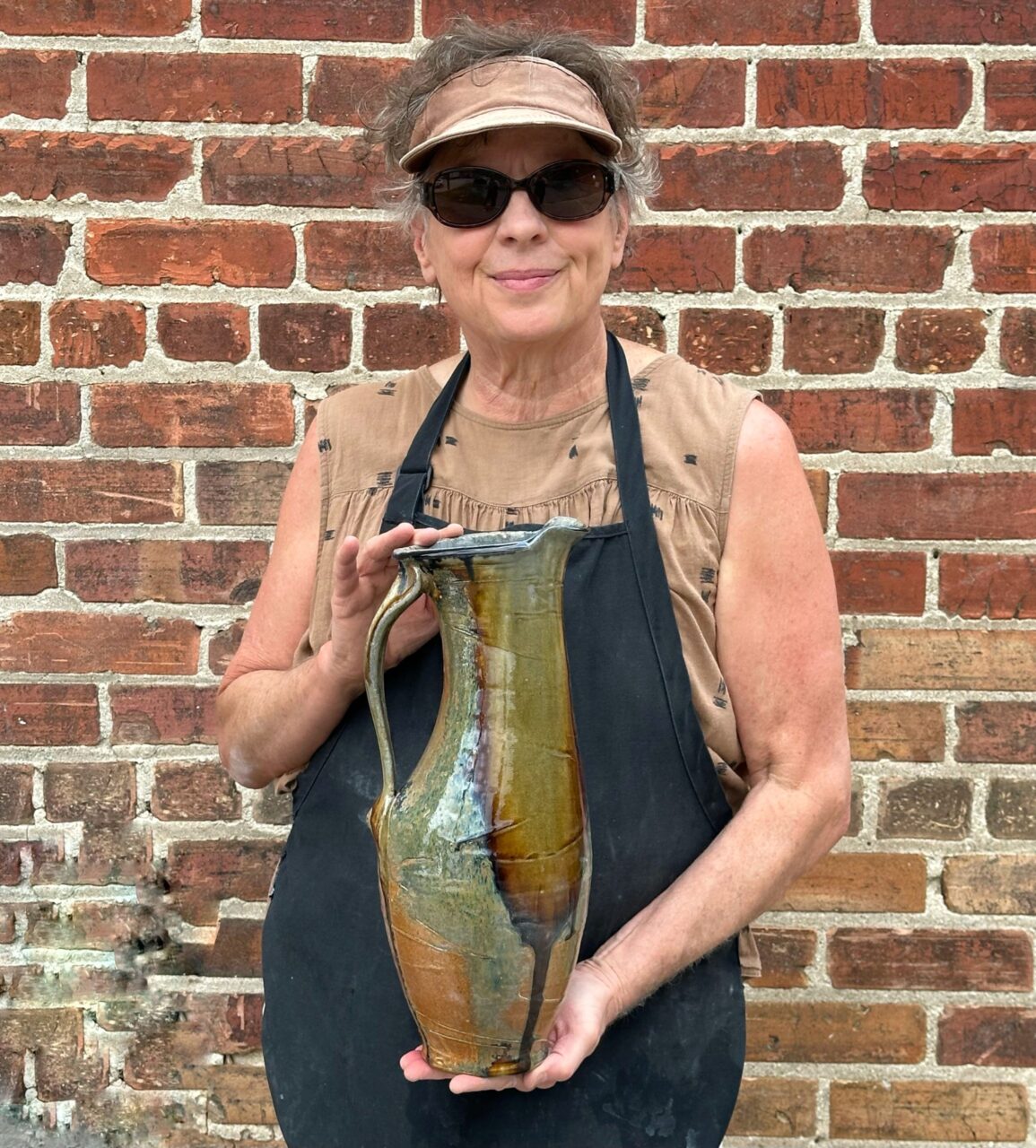 Sarah Wells Rolland holding finished pot, wood soda kazie pitcher Sarah Wells Rolland holding finished pot, wood soda kazie pitcher
