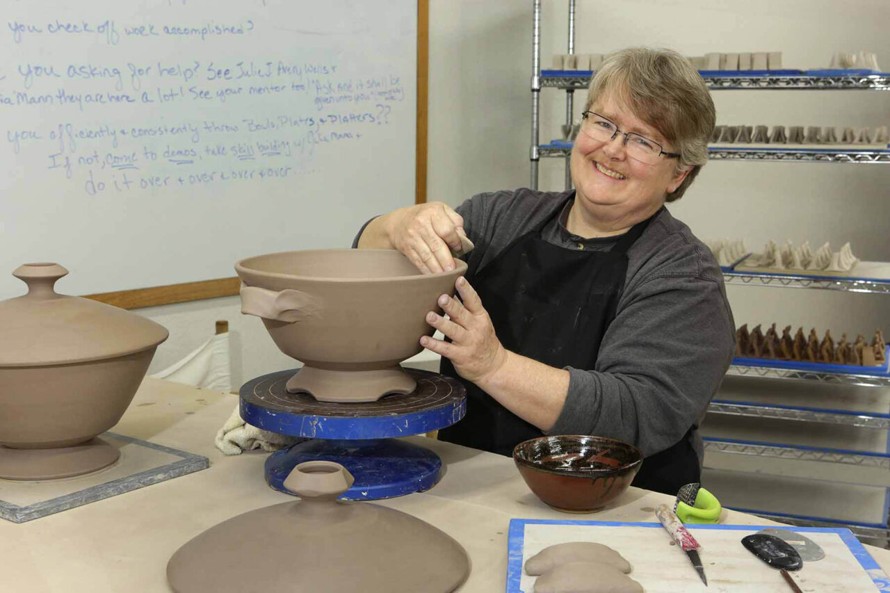 Julia Mann working on leather hard soup tureen, smiling Julia Mann working on leather hard soup tureen, smiling